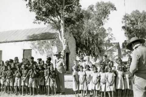 Children lined up outside schoolhouse