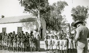 Children lined up outside schoolhouse