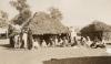 Aboriginal people outside thatched huts 1923